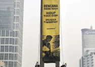 Aktivis Greenpeace membentangkan spanduk di Bundaran HI