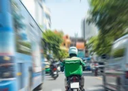 Ilustrasi pengemudi ojek online sedang membawa barang pesanan pelanggan