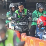 Ilustrasi pengemudi transportasi daring menggunakan gawai di jalan raya.