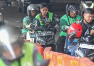 Ilustrasi pengemudi transportasi daring menggunakan gawai di jalan raya.