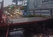 Petugas kepolisian sedang menangani kecelakaan dua truk di depan gedung DPR RI