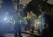 Petugas mengamankan area jalur rel kereta api di perlintasan KRL