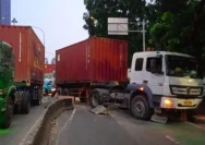 Petugas mengevakuasi truk kontainer yang menabrak separator jalan di kawasan Tomang Jakarta Barat