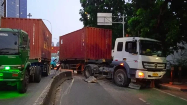 Petugas mengevakuasi truk kontainer yang menabrak separator jalan di kawasan Tomang Jakarta Barat
