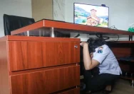Seorang ASN berlindung di bawah meja saat simulasi gempa bumi di Jakarta Selatan