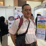 Perjuangan Agung Mencari Pekerjaan di Usia 47 Tahun Melalui Bursa Kerja Seorang pria paruh baya sedang melihat informasi lowongan pekerjaan di bursa kerja