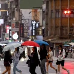 Warga Taiwan beraktivitas di tengah hujan saat Topan Champi mendekati wilayah tersebut