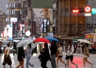 Warga Taiwan beraktivitas di tengah hujan saat Topan Champi mendekati wilayah tersebut